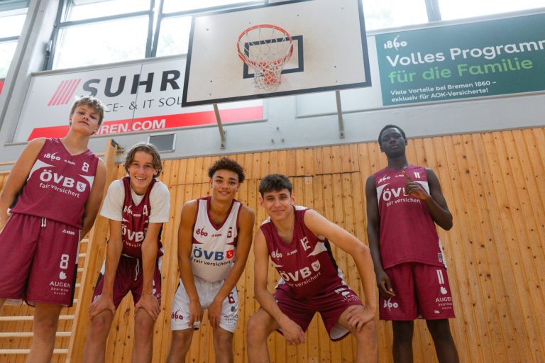 Gruppe von Jugendspielern posiert vor dem Korb