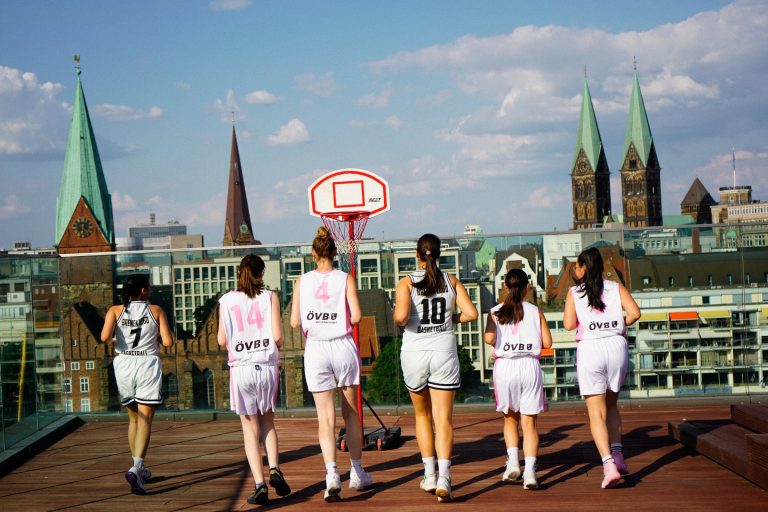 Damen- und Mädchenteam laufen über die Dachterrasse, im Hintergrund Dom und Liebfrauenkirche